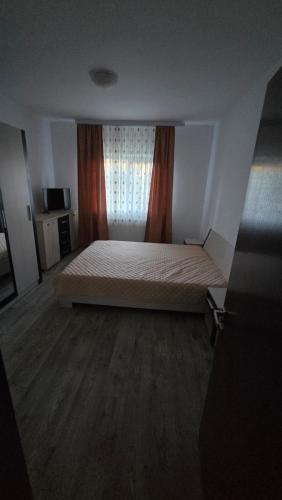 a bedroom with a large bed with a window at Casă in Năvodari