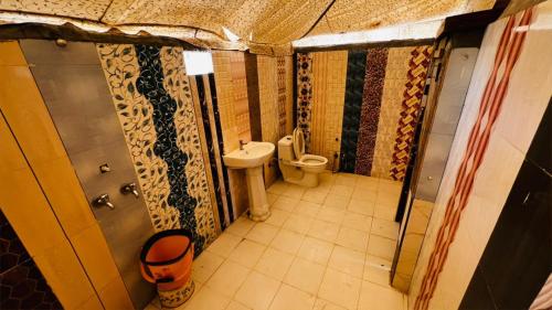 a small bathroom with a toilet and a sink at Big Brand Desert Camp in Jaisalmer