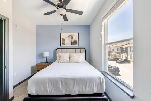 a bedroom with a bed with a ceiling fan at Landing Modern 3BD Gym Rooftop Lounge in Bellview