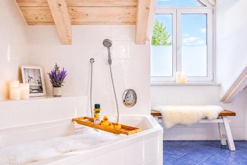 a white bathroom with a tub and a sink at Bright Lake View Apartment with Balcony and Air Conditioning in Tutzing