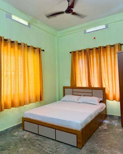 a bedroom with a bed with orange curtains at Southern Residency in Ferokh