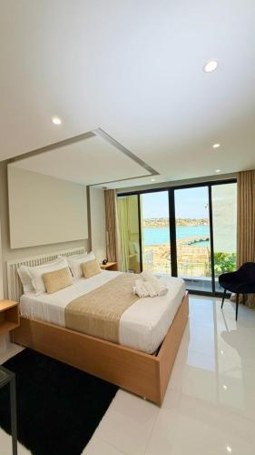 a bedroom with a large bed with a large window at Vista Mar Suites in Praia