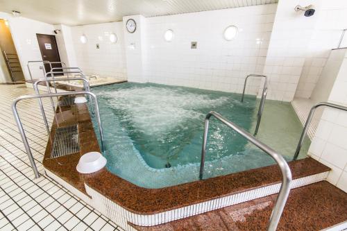 a large jacuzzi tub in a room with water at Capsule&Spa Grand Sauna Hiroshima (Male Only) in Hiroshima