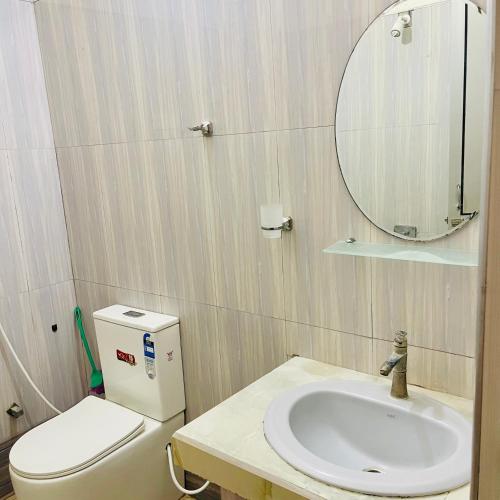 a bathroom with a sink and a toilet and a mirror at The Dream City Hotel in Kilinochchi