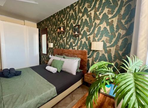 a bedroom with a bed and a green wall at Tropical Morabeza Apartment Santa Maria in Santa Maria