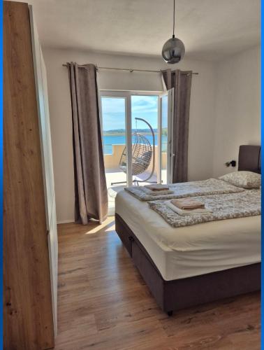 a bedroom with a bed and a view of the ocean at Guesthouse Maro in Povljana
