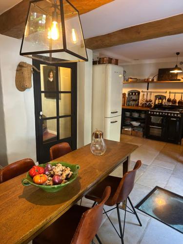 a kitchen with a table with a bowl of fruit on it at L'aile du Chateau in Ramatuelle