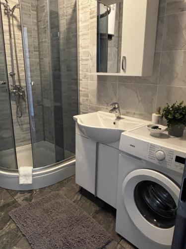 a bathroom with a washing machine and a sink at Modern Panoramic Sea View Apartment with Large Terrace in Pag