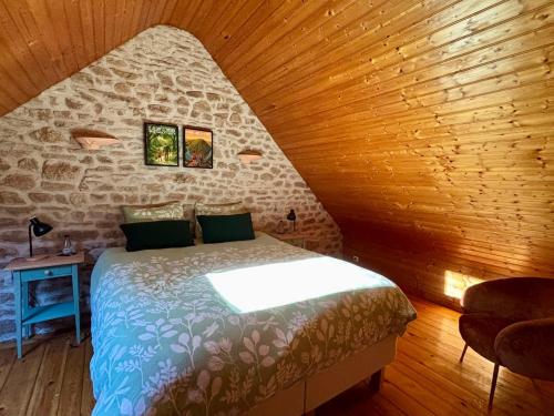 a bedroom with a bed in a wooden room at Le Gîte de Couturas in Saint-Hilaire-les-Courbes
