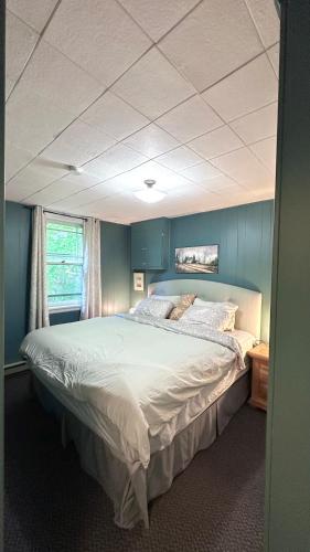 a bedroom with a large bed with blue walls at Falcon Retreats in Sharbot Lake