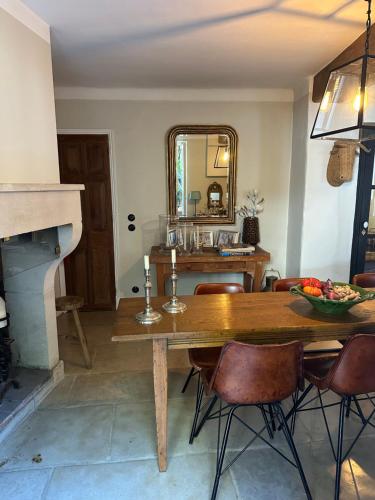 a dining room with a table and a mirror at L'aile du Chateau in Ramatuelle