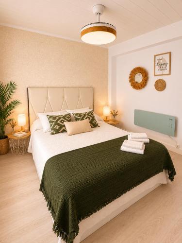 a bedroom with a large bed with a green blanket at Abuela Maruja - Piso acogedor en Cee, perfecto para desconectar in Cee