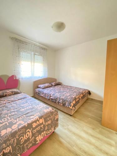 a bedroom with two beds and a window at Batica in Radanovići