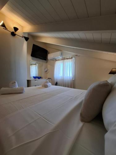 a large white bed in a room with a window at Stefanos Studios in Lassi