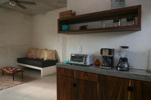a kitchen with a counter with a blender and a couch at Villas H2O in Tulum