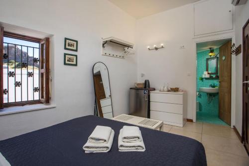 a room with a bed and a bathroom with a sink at Al 583 di Lindos in Lindos