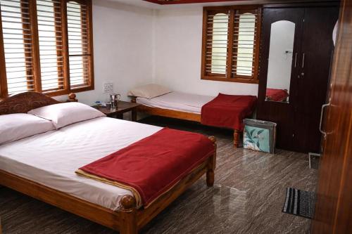 a bedroom with two beds in a room with windows at Gramasiri Homestay in Sringeri