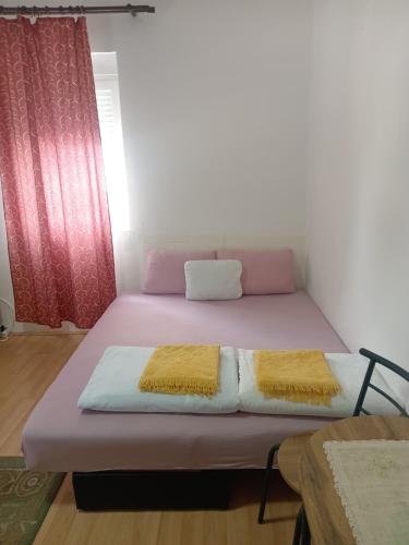 a bed with two pillows on it in a room at Palamar in Kuršumlija