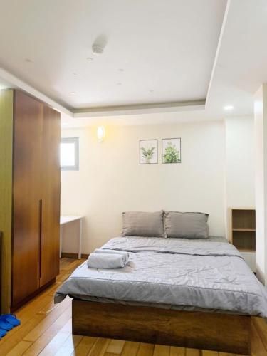 a bedroom with a bed and a wooden cabinet at ROSE Appartment in Ho Chi Minh City
