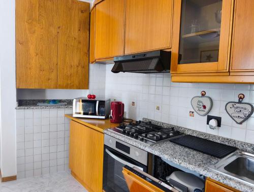 a kitchen with wooden cabinets and a stove top oven at NicoMeli Home in Dimaro