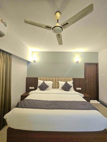 a bedroom with a large bed with a ceiling fan at Casa Sevara Hotel in Vagator