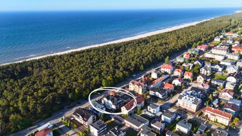 an aerial view of a town next to the beach at Morskie Oko - Noclegi 100 do Plaży - Pokoje i Studia z Aneksami Kuchennymi in Karwia