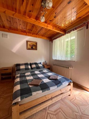 a bedroom with a bed in a room with wooden ceilings at Pokoje Gościnne Ojcowska Kraina Pieskowa Skała Ojców in Pieskowa Skała