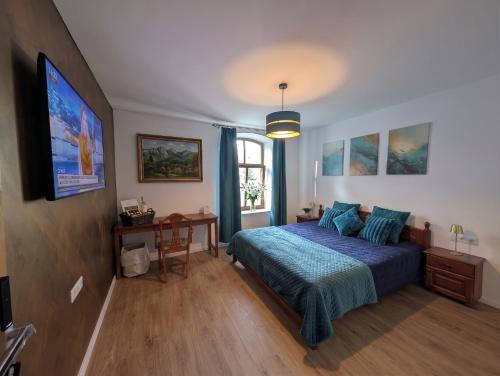 a bedroom with a blue bed and a window at Templomdomb Apartmanház in Tapolca