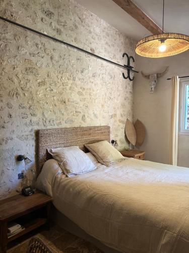 a bedroom with a bed and a lamp and a wall at chambre aux moutons in Saint-Méard-de-Gurçon