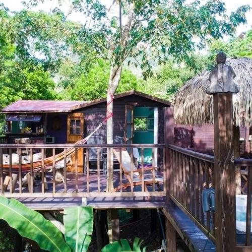 a wooden house with a porch and a deck at Cabanes rêve d'enfant in Les Anses-dʼArlets