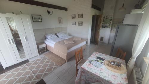 a small room with a bed and a table and a table and chairs at Domek w Zaciszu in Cieszyno