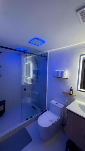 a bathroom with a toilet and a glass shower at Luxury Condo at Live Jaco Tower in Jacó