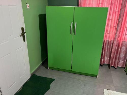 a green cabinet in the corner of a room at Electra Serviced 1 Bedroom Apartment, Lagos in Iju Junction