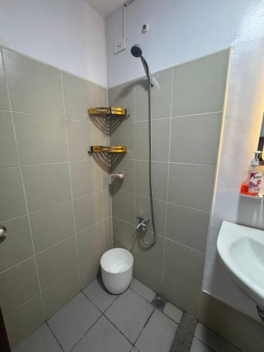 a bathroom with a shower and a toilet and a sink at Staycation Hub in Mandaue City