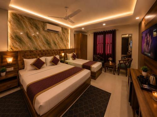 a hotel room with two beds and a television at Hotel Bellamontan Suites Near Delhi Airport - Free Airport Pickup & Drop in New Delhi