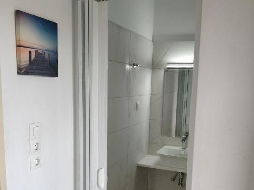 a white bathroom with a sink and a mirror at Thaleia Studios & Apartments in Kavos