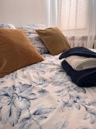 a bed with a blue and white blanket and pillows at Apartament Szafir in Gdańsk