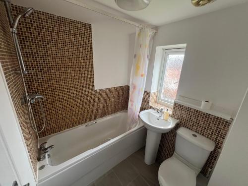 a bathroom with a sink and a toilet and a shower at Favour homes in Manchester