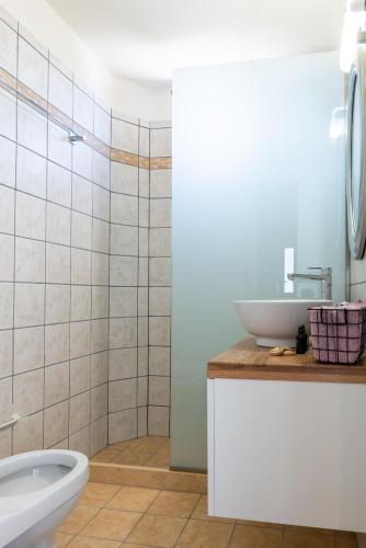 a white bathroom with a sink and a toilet at Stone Cottage in Morónion