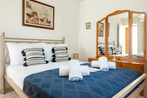 a bedroom with a blue and white bed with a mirror at Stone Cottage in Morónion