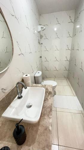 a white bathroom with a sink and a mirror at Villa Serrinha - Sitio Paraiso in Serrinha
