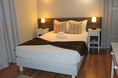 a bedroom with a large bed with two night stands at Hotel Porto Nobre in Porto