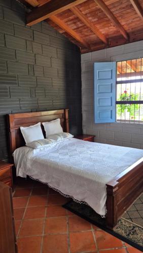 a bedroom with a large bed with a blue window at Casa campestre in Guarne