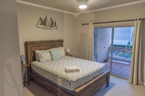 a bedroom with a bed and a balcony at Mariners Village Tranquil Condo in Seabrook