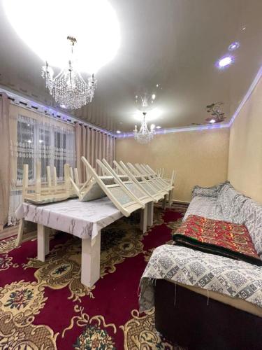 a room with a table and two beds in it at Arlanguesthouse in Dzhangyaryk