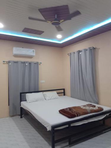 a bedroom with a bed with a ceiling fan at Shree krishn yatri nivas in Ellora