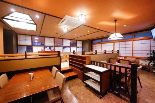 a restaurant with wooden tables and chairs and tables sidx sidx sidx at Dormy Inn Toyama Natural Hot Spring in Toyama