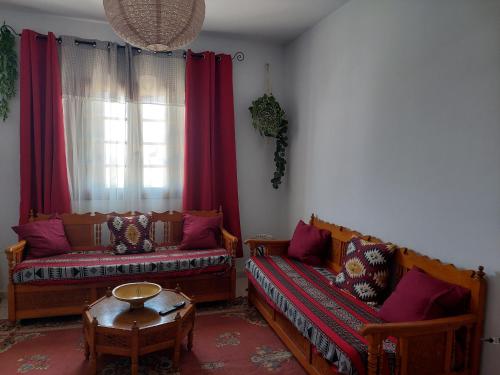 a living room with two couches and a table at Résidence Kyranis appartement Noix de Coco in Sfax