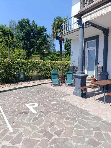 two chairs sitting on a stone patio next to a building at Ca' de' Mari at Como - Switzerland - Private Parking - Self Check-In in Faloppio