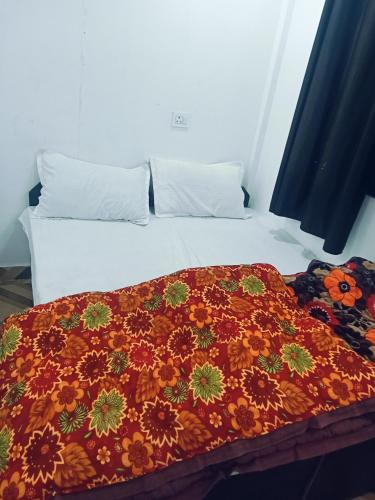 a bed with a colorful blanket on top of it at Punchkedar in Phata